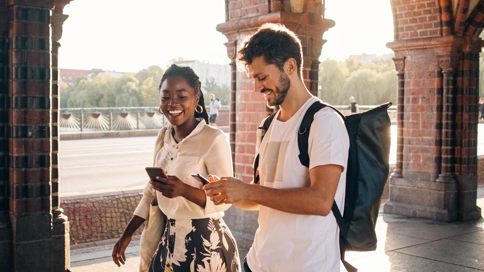 Two friends smiling while looking at their phone